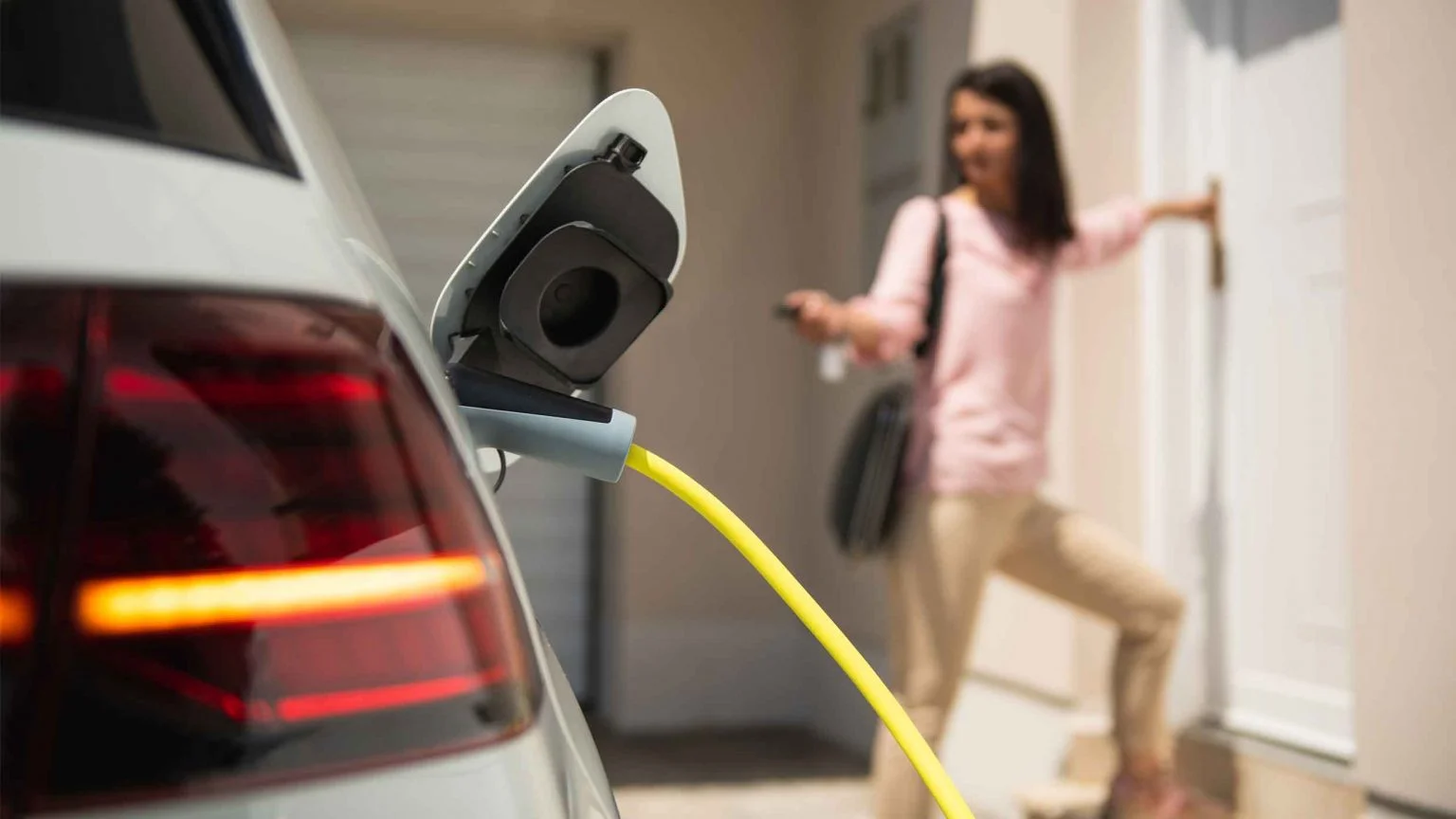 Ev charging with Woman entering her home