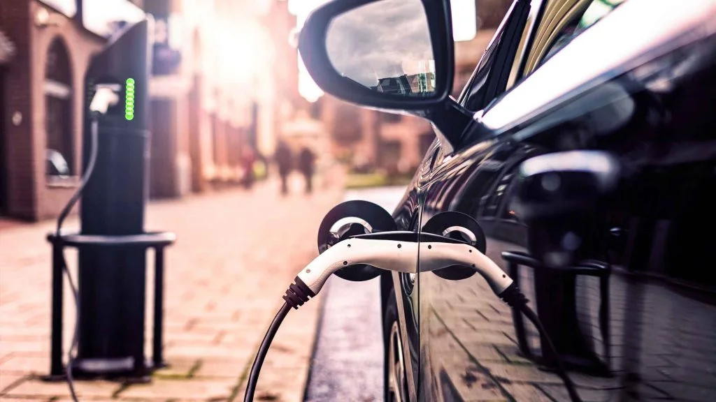 A parked electric car charging in the street