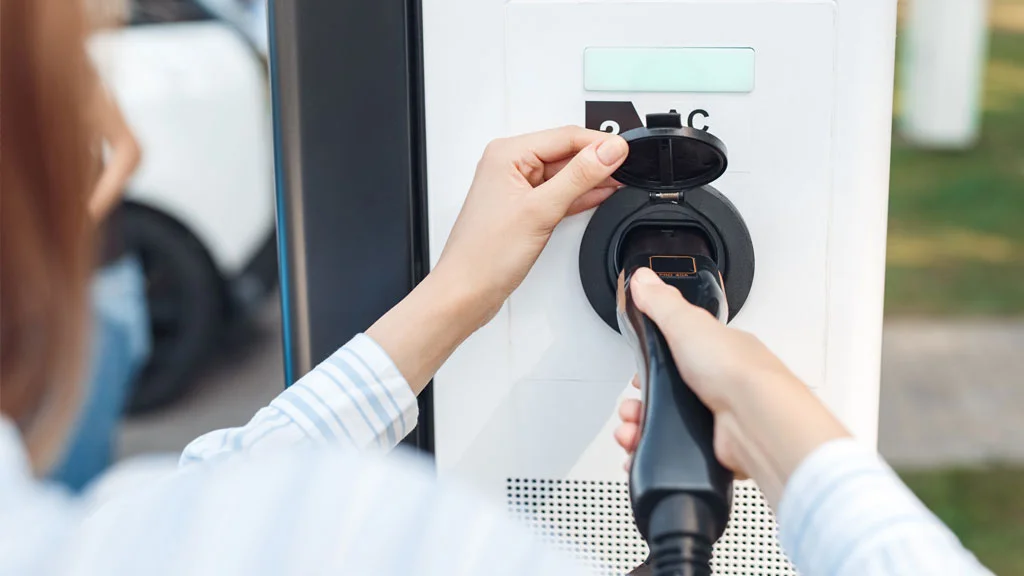 Woman using public ev charge point