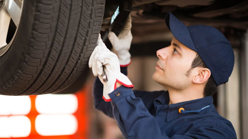 Man inspecting a car on a car lift