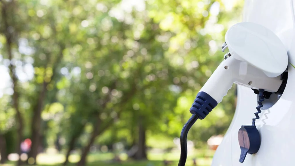 An EV being charged in the countryside. Lower Running Costs.