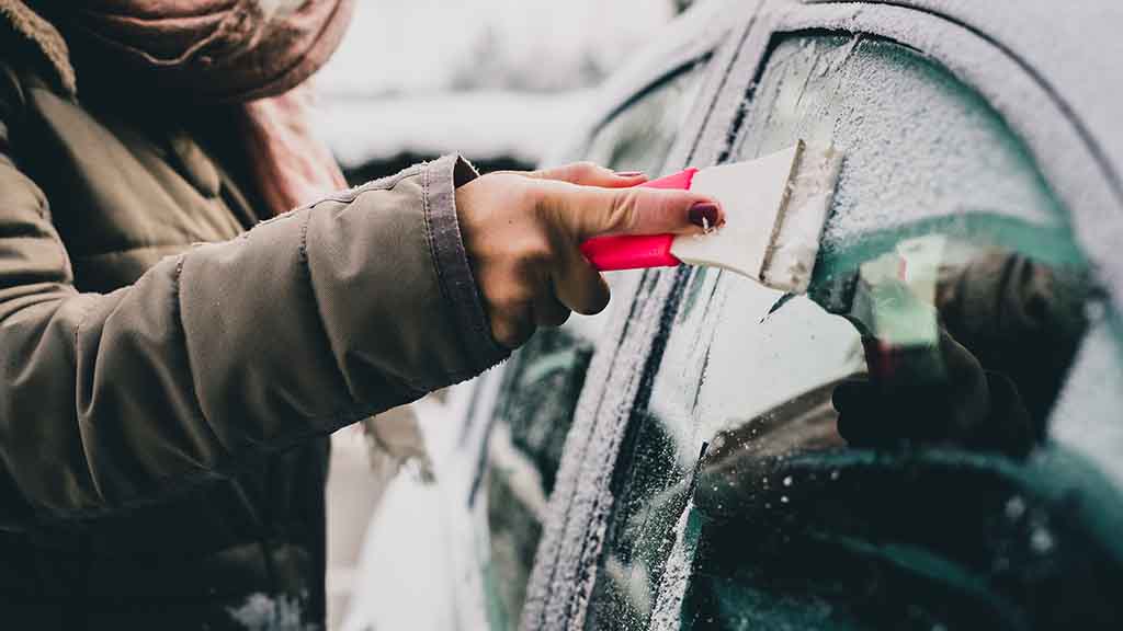 Person scraping Ice of their Car