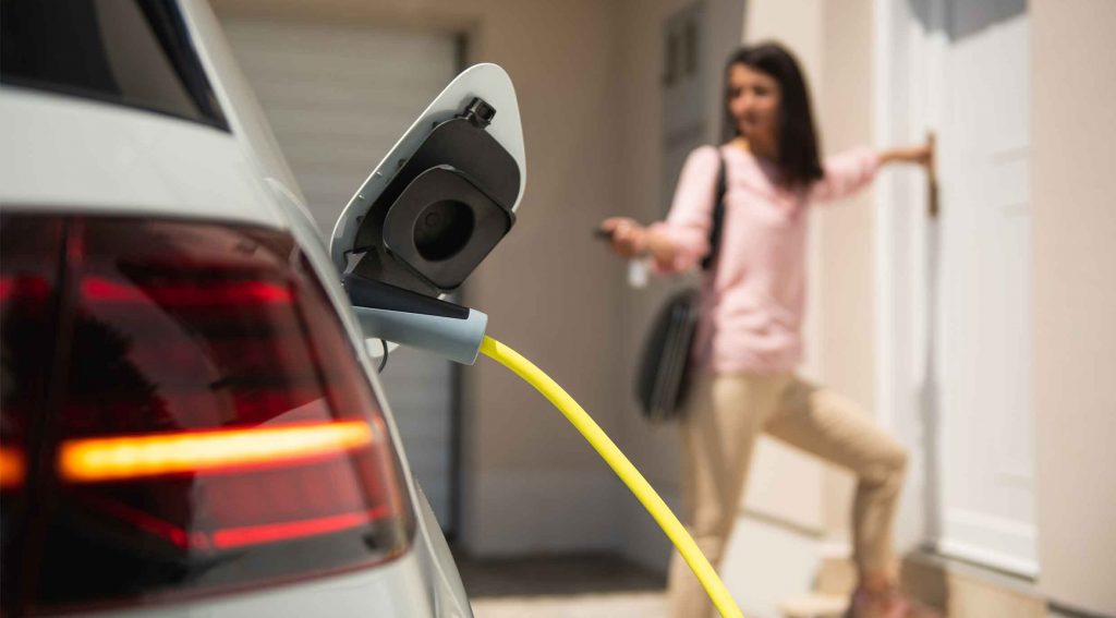 Ev charging with Woman entering her home