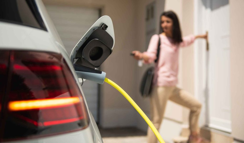 Ev charging with Woman entering her home