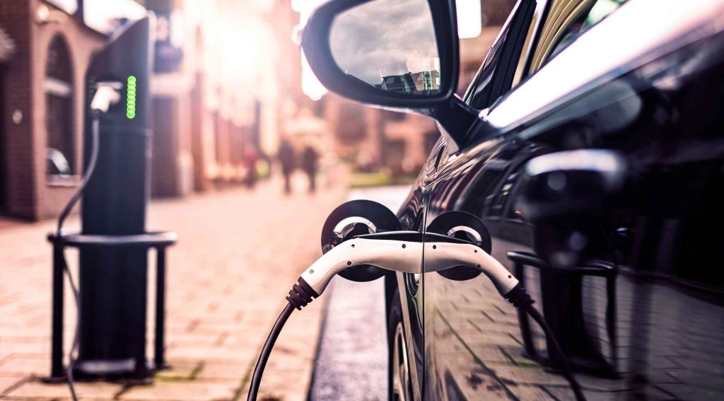 A parked electric car charging in the street