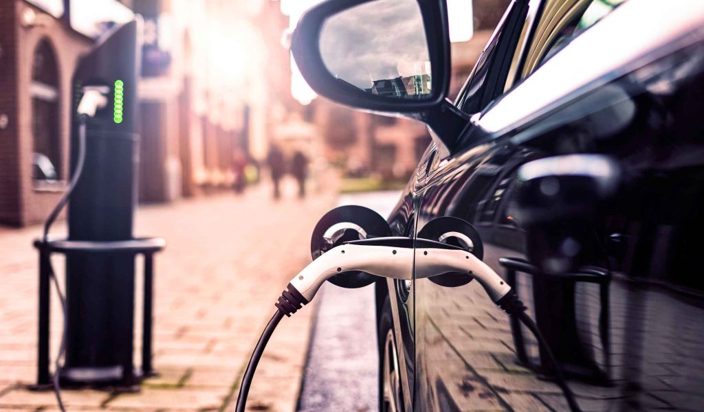 A parked electric car charging in the street