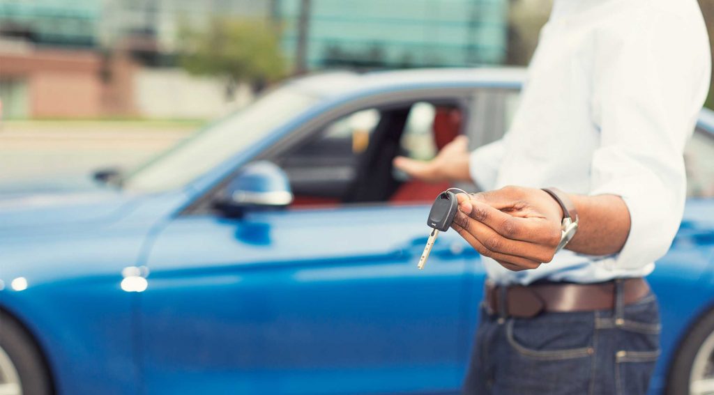 A Man holding the key to a new EV