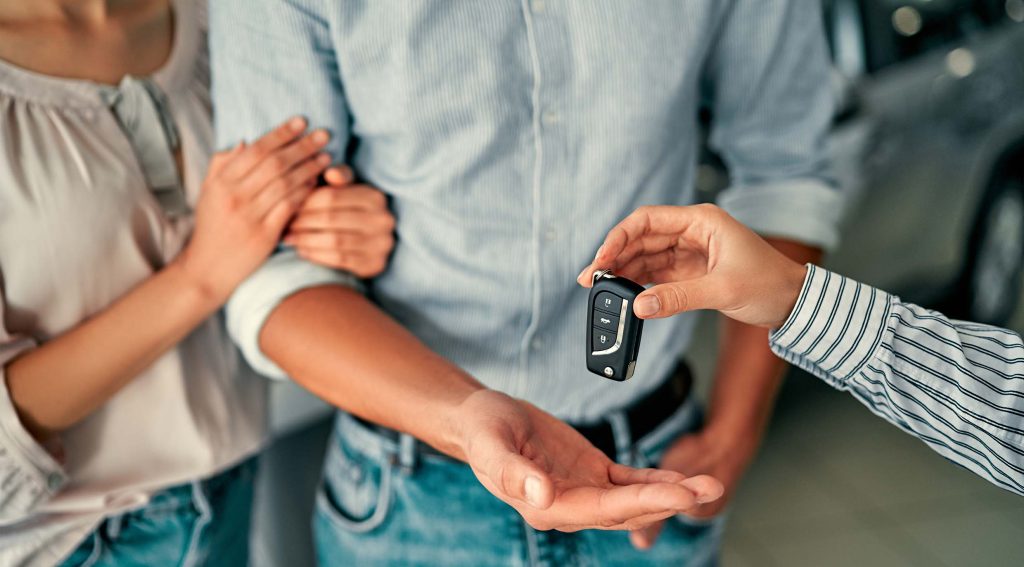 Couple being handed keys to car