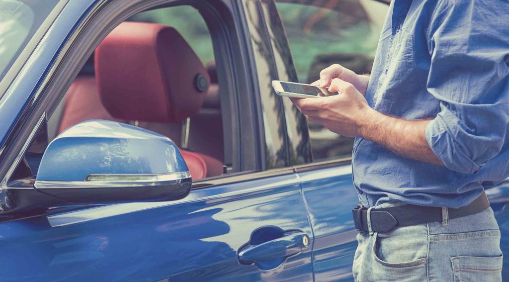 Person using remote app controls outside of a car
